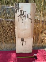 Panel positioned against a bamboo screen outdoors, showing front view and chair designs.