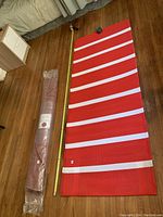 6.5-foot red and white runner rug fully unrolled alongside a tape measure and a rolled rug in packaging