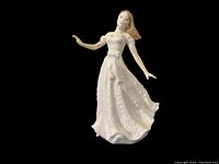 Front view showing the full gown with floral design and the serene expression of the woman.