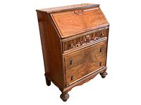 Front corner view showing closed slant top and three lower drawers