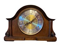 Front view of the wooden Bulova mantle clock showing the clock face and case with scroll side details.