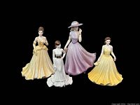 Front view of four vintage porcelain figurines including three ladies in various colored gowns and one woman with a lavender hat