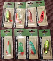 Set of 8 Canadian Northern fish lures in original packaging displayed on reddish fabric background