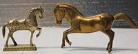 Photo showing two brass horse figurines side by side, displaying size and patina