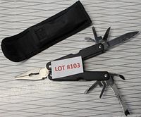 Gillette 9-in-1 multi-tool partially unfolded showing pliers, blade, screwdrivers, file and other tools with black handles next to black nylon sheath.