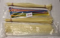 All zip ties, mostly natural color with some colorful ones, laid on a white surface, showing overall lot contents