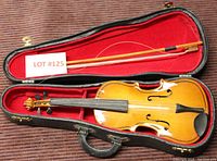 Violin, bow and case with Lot number card visible from above view showing the violin inside the open case