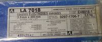 Close-up photo of the sealed box label showing specifications and brand details of the welding electrodes