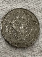 Front side of the coin showing floral design and inscriptions 'MANITOBA 1870-1970 CANADA DOLLAR'.
