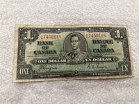 Front of 1937 Canadian one dollar banknote showing the portrait of King George VI with serial numbers and signatures.