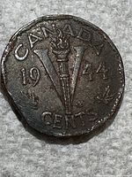 Close-up of the 1944 Canadian 5 cents coin showing the front with the 'V' and torch design, date, and maple leaves.