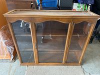 Front view of antique wooden hutch with closed glass doors and metal handles
