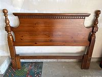 Vintage solid wood Kroehler headboard showing turned posts with rounded finials and carved top edge detail in medium-brown finish.