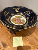 Full view of the large cobalt blue pedestal vase/bowl with gold detailing and painted scene in the center