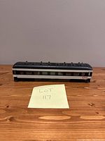 Front and side view of vintage CN passenger coach model train car on wooden surface with lot number note.