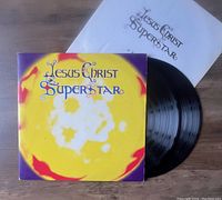 Jesus Christ Superstar vinyl record set with cover, two records, and lyric insert shown on wooden surface.