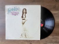 Vinyl LP record partially outside album cover showing 'Coal Miner's Daughter' album by Loretta Lynn.