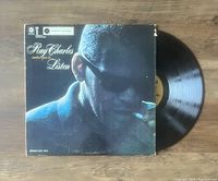 Photo showing the front cover of the vinyl album 'Ray Charles Invites You To Listen' and part of the vinyl record pulled out from the sleeve.