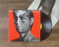 The album cover of Rolling Stones Tattoo You LP and the vinyl record partially outside the sleeve.