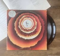 Photo of the vinyl record partially out of the album cover, showing cover art and record condition.