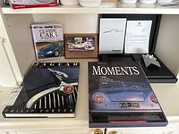 Three hardcover books and wooden cube puzzle arranged on shelf