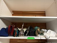 Seven purses displayed on white shelving