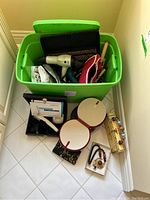 Green bin containing hair styling tools including Berophe Labor hair dryer, curling iron, and pouch of hair rollers visible.