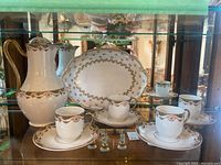 Overview of 10-piece tea service: 4 cups, 4 saucers, teapot, oval platter.