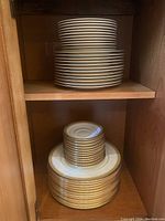 Two shelves with stacks of larger and medium plates