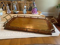 Front-angle view of rectangular tray showing brass faux bamboo handles and wood veneer surface