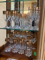 Full display of stemmed glasses and tumblers on glass shelving