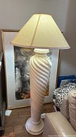 Full view of tall floor lamp with twisted column base and beige fabric shade, showing overall shape and condition.