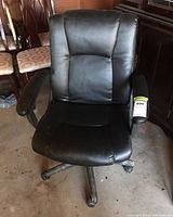 Front view of the black office chair showing padded seat and tufted backrest