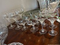 Side-angle view of 12 Rosenthal crystal stemware glasses arranged in three size groups, showing the clear crystal material, cut pattern on bowls, and starburst base designs.
