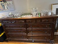 Front view of the wood sideboard dresser showing seven drawers with metal hardware, carved drawer fronts, and dark wood finish.