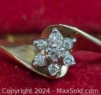 Close-up of ring's floral cluster setting with small round diamonds on 10K gold band