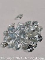 Photo showing multiple loose genuine aquamarine gemstones with light blue transparent coloration and various cuts.