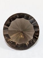 Top view of round faceted smokey quartz gemstone showing dark smoky brown color and symmetric facets.
