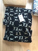 Folded black and white Berber fabric with abstract pattern shown on wooden floor with tag indicating 45