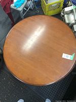 Top view showing the round maple tabletop surface with minor scratches and wear.