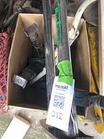 Photo showing multiple old car jacks in a box, including black bottle jack, black jack with square base, long black bar with 'PRO-LIFT' label, yellow and white jack frames.