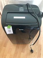 Front view of black Danby portable air conditioner showing brand logo, power cord, and top control panel.