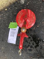 Photo of the vintage red bean cutter showing the round cast iron part with embossed text, wooden handle, and metal cutting component.