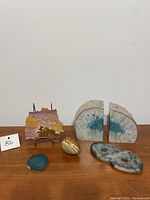 Wide view showing all six stone and crystal items including the quartz bookends, soapstone infinity symbol, stone egg, agate slice, layered stone piece on stand, and another small stone object.