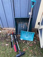 Image showing all items grouped: large black metal snow shovel, medium turquoise plastic shovel, and three vehicle brushes with scrapers.