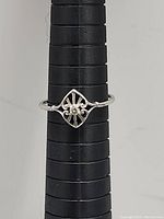 10k white gold ring with diamond set in an openwork decorative design on ring sizer.