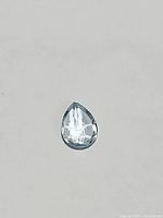 Single loose pear-shaped sky blue topaz gemstone on a plain background showing full stone shape and cut.