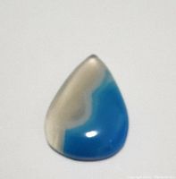 Close-up photo of a teardrop-shaped polished agate gemstone with blue and white stripes, showing glossy finish and natural banding.