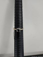 Front view of the 10K gold ring showcasing the black diamond center stone and white diamond accents on the band.