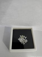 Photo showing assorted loose diamonds in a white container with black insert.